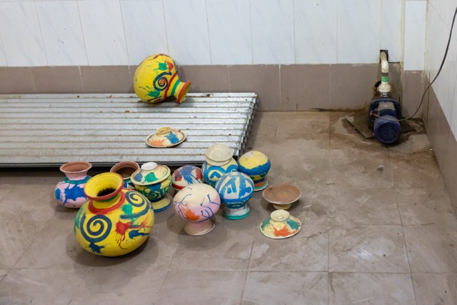 Colourful clay pots lie on a dusty floor beside a water pump inside the Rabindra Memorial complex at Pithabhog village in Khulna, Bangladesh. Photo: Nayem Ali