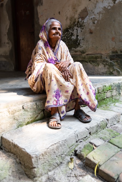 Sayarani Kushari, from the sixteenth generation of Rabindranath Tagore’s Kushari lineage and now close to a hundred, sits on a concrete step outside her home near the Rabindra Memorial complex in Pithabhog village in Khulna, Bangladesh. Photo: Nayem Ali